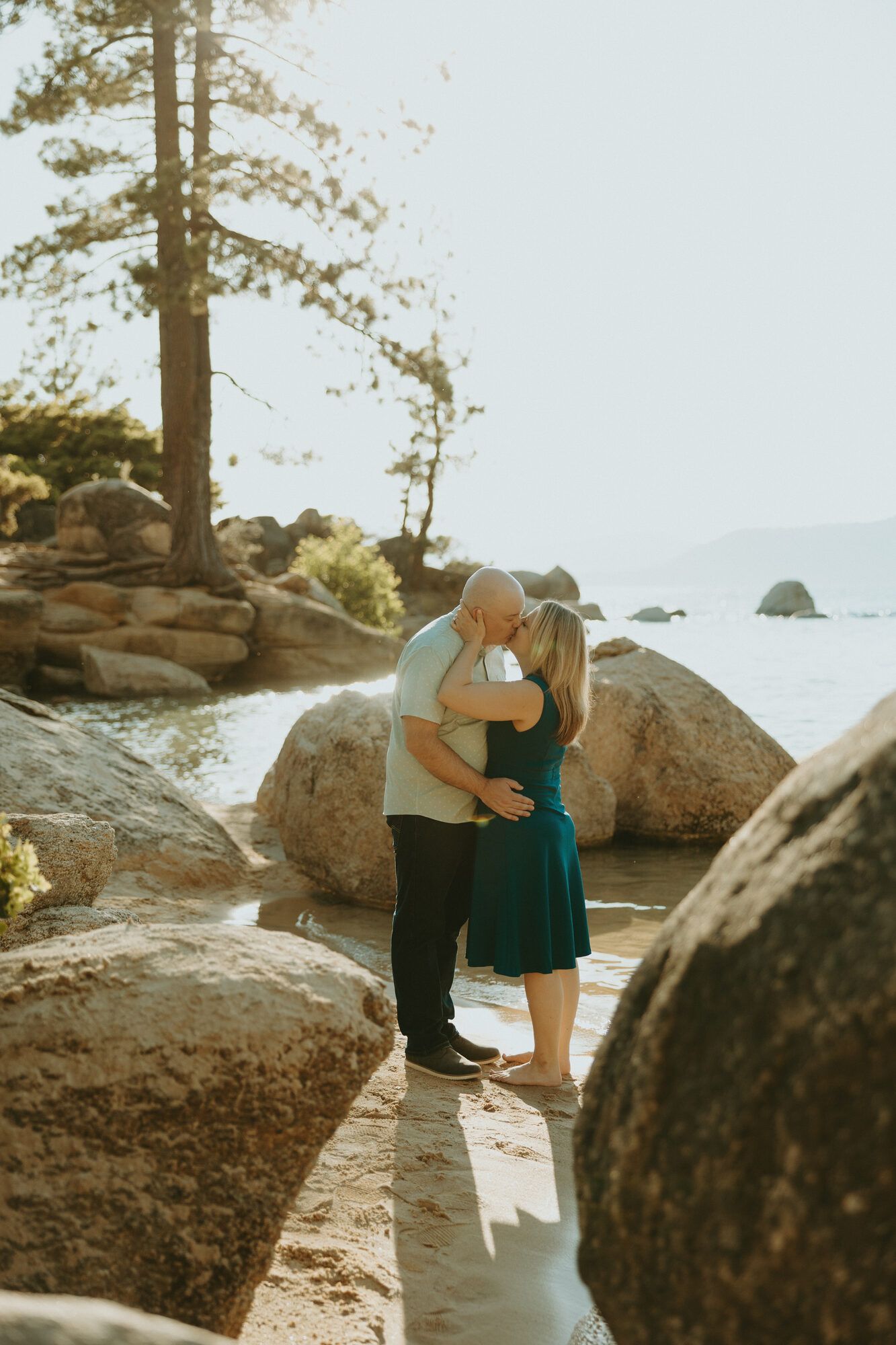 A kiss framed between granite boulders on the Lake Tahoe shore