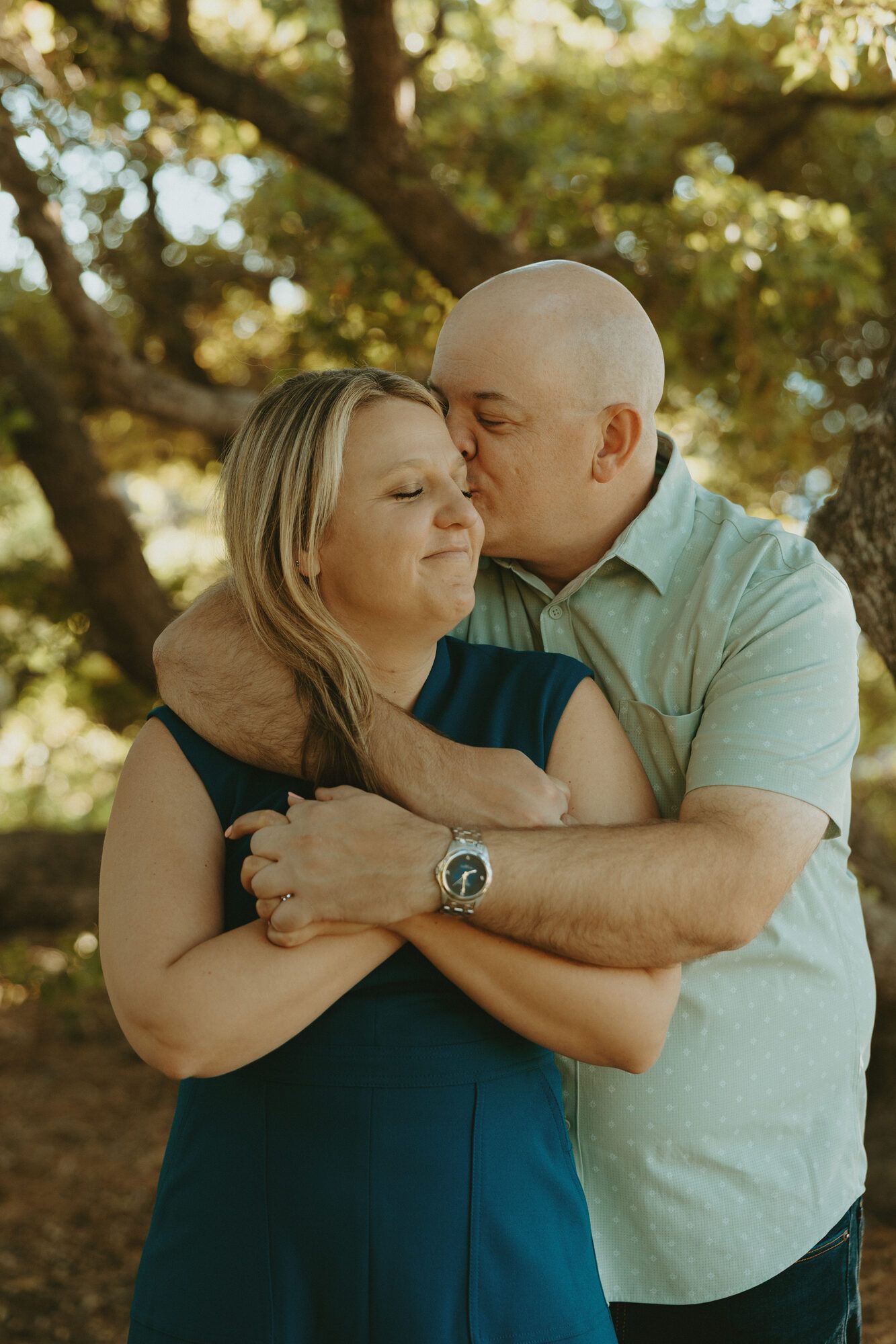 Eric kissing the top of Nicole’s head as she smiles contentedly