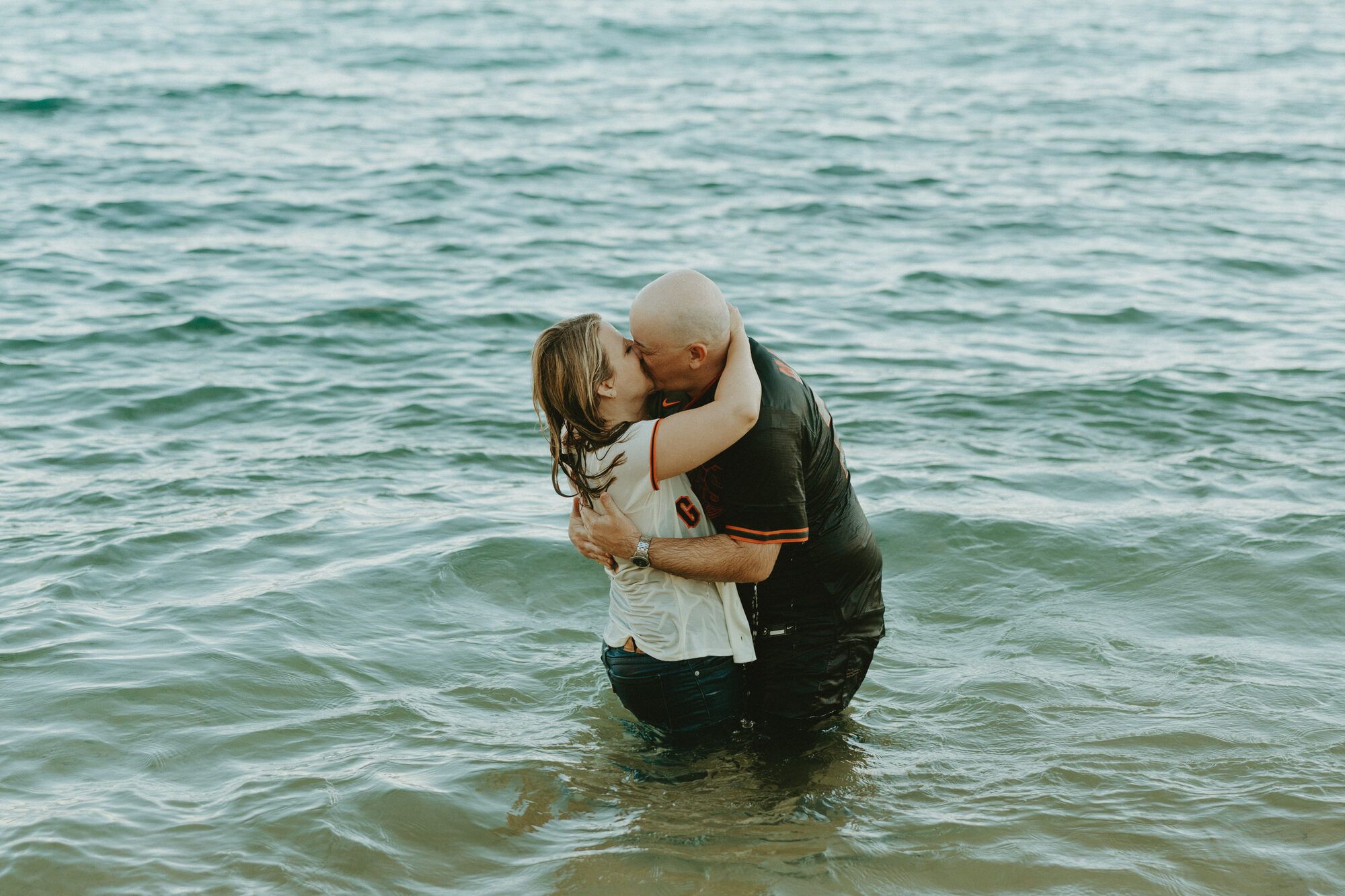 A kiss standing in the teal waters of Lake Tahoe